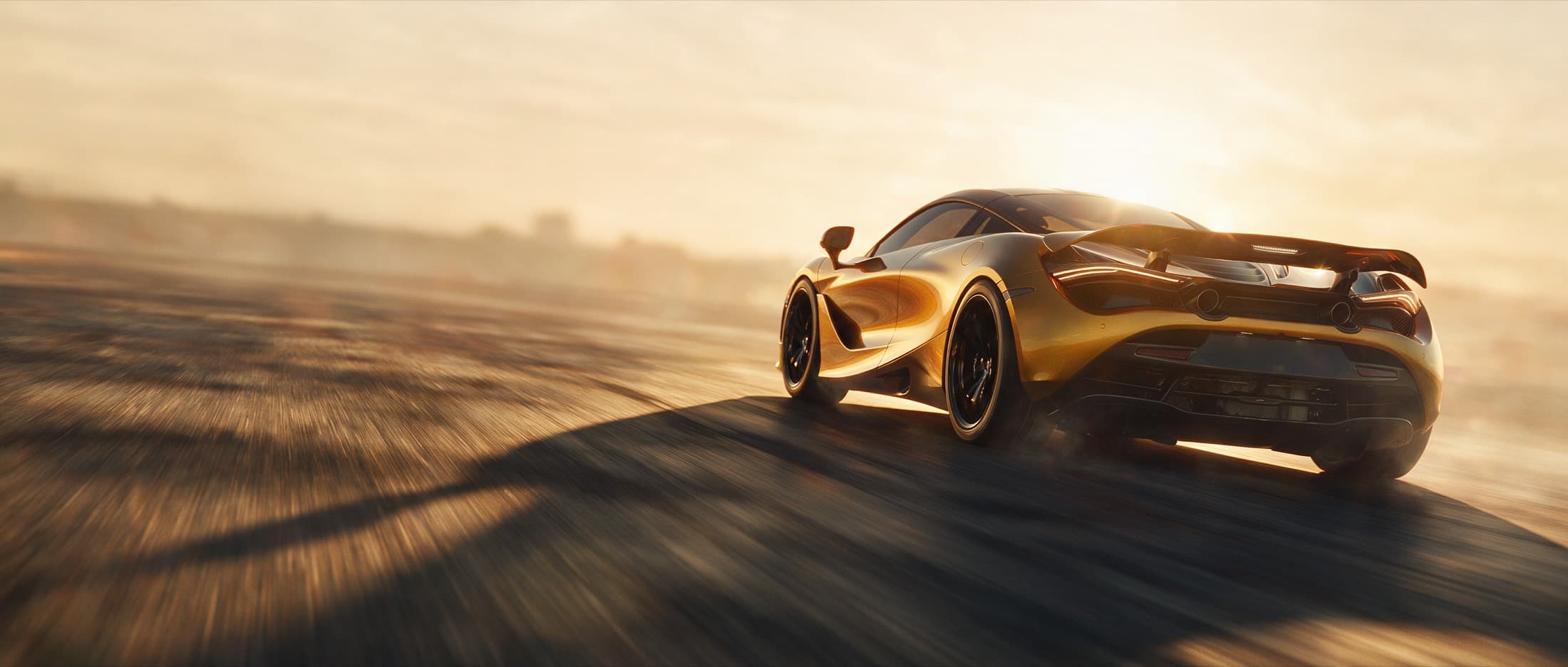 A gold supercar accelerating along an open road at sunset
